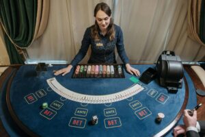 Casino dealer managing a card table with chips and betting layout