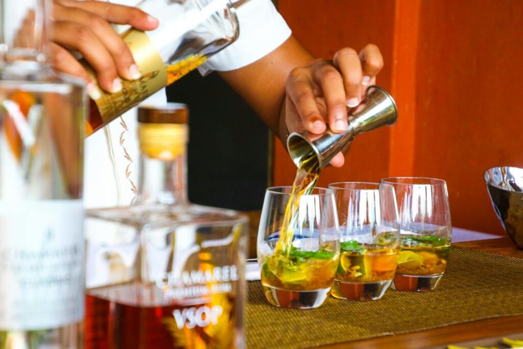 Hospitality worker pouring spirits into glasses at a bar