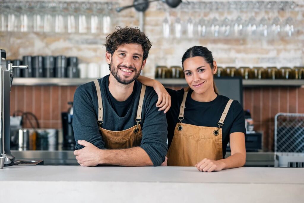 Two hospitality workers behind the bar